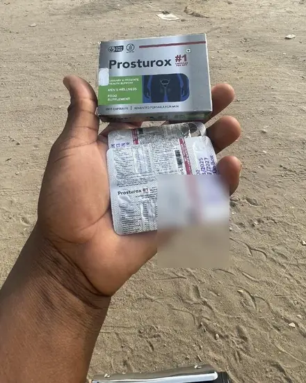 Boîte et plaquette de Prosturox tenues dans la main, en extérieur