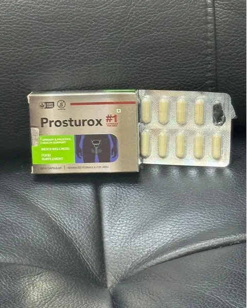 Boîte de Prosturox et plaquette de gélules beiges sur un siège en cuir