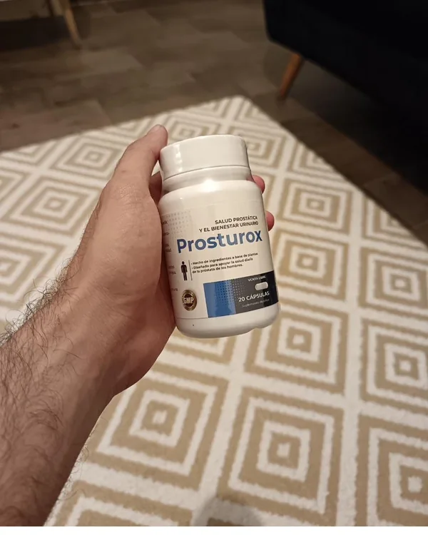 Un frasco de Prosturox en la mano sobre una alfombra